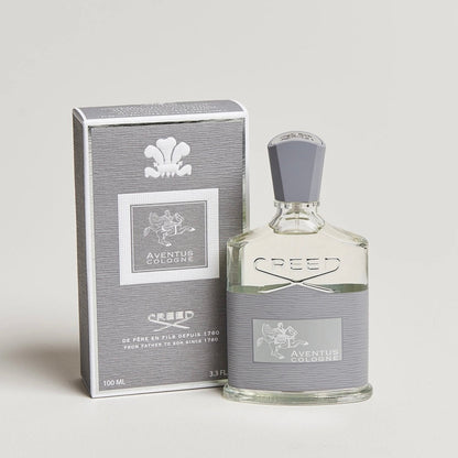Creed Aventus cologne bottle and packaging on a light gray background
