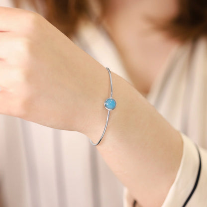 Silver rhodium plated bangle with blue quartz